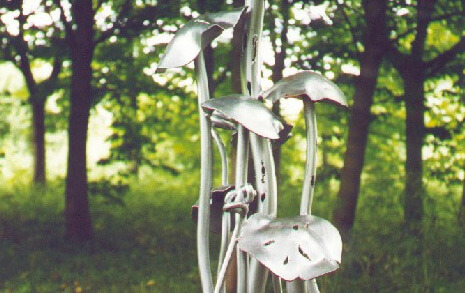A close up of a statue of mushrooms with trees in the background